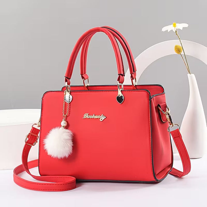 Sanika – Handtasche Mit Pompon Anhänger Und Schulterriemen